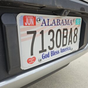 Closeup of the license plate tool holder (LPTH) set installed on a Rivian R1T with no license plate frame.